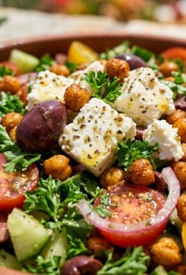 Ultra close-up macro of loaded Mediterranean chopped salad with crispy spiced chickpeas, cucumbers, tomatoes, and herb feta