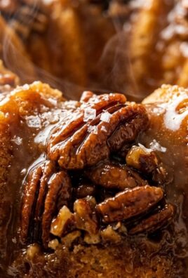Ultra close-up macro food photography of rich Southern pecan upside-down bundt cake with warm brown sugar caramel glaze and toasted pecans