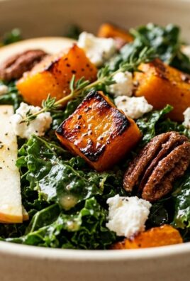 Ultra close-up macro of warm roasted butternut squash and kale salad with candied pecans and goat cheese